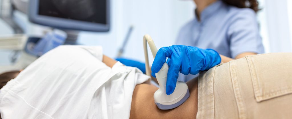 Doctor conducts ultrasound examination of patientv kidneys. Internal organs ultrasound concept. female's lower back diagnosis carried out with the use of an ultrasound