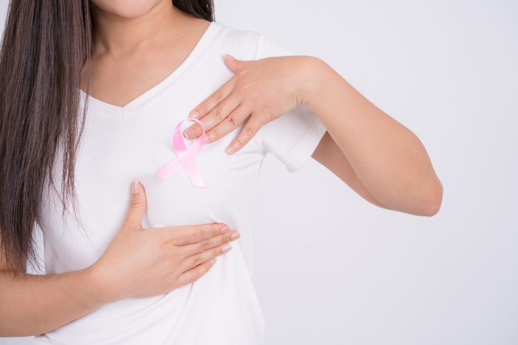 Close-up of a pink banner ribbon on a woman's chest in support of breast cancer causes and health care.